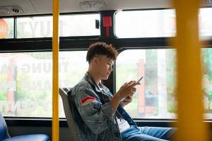 A man watches a webcast on the bus with subtitles