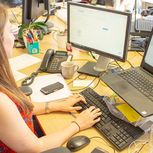 One of Public-i helpdesk working on her computer