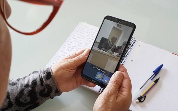 Councillor attending to a hybrid meeting on her phone